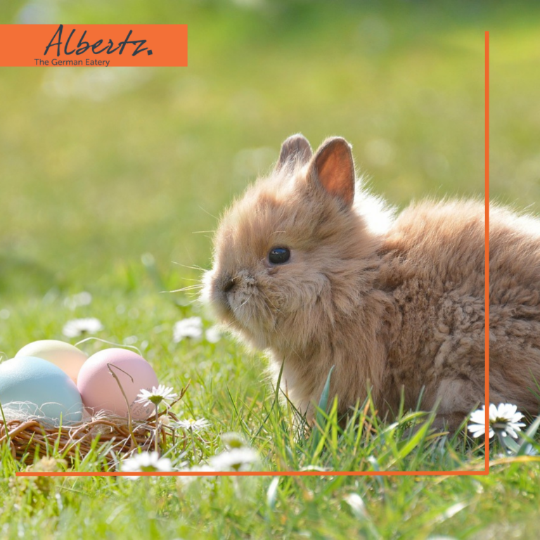 Ein Hase neben bunten Eiern.